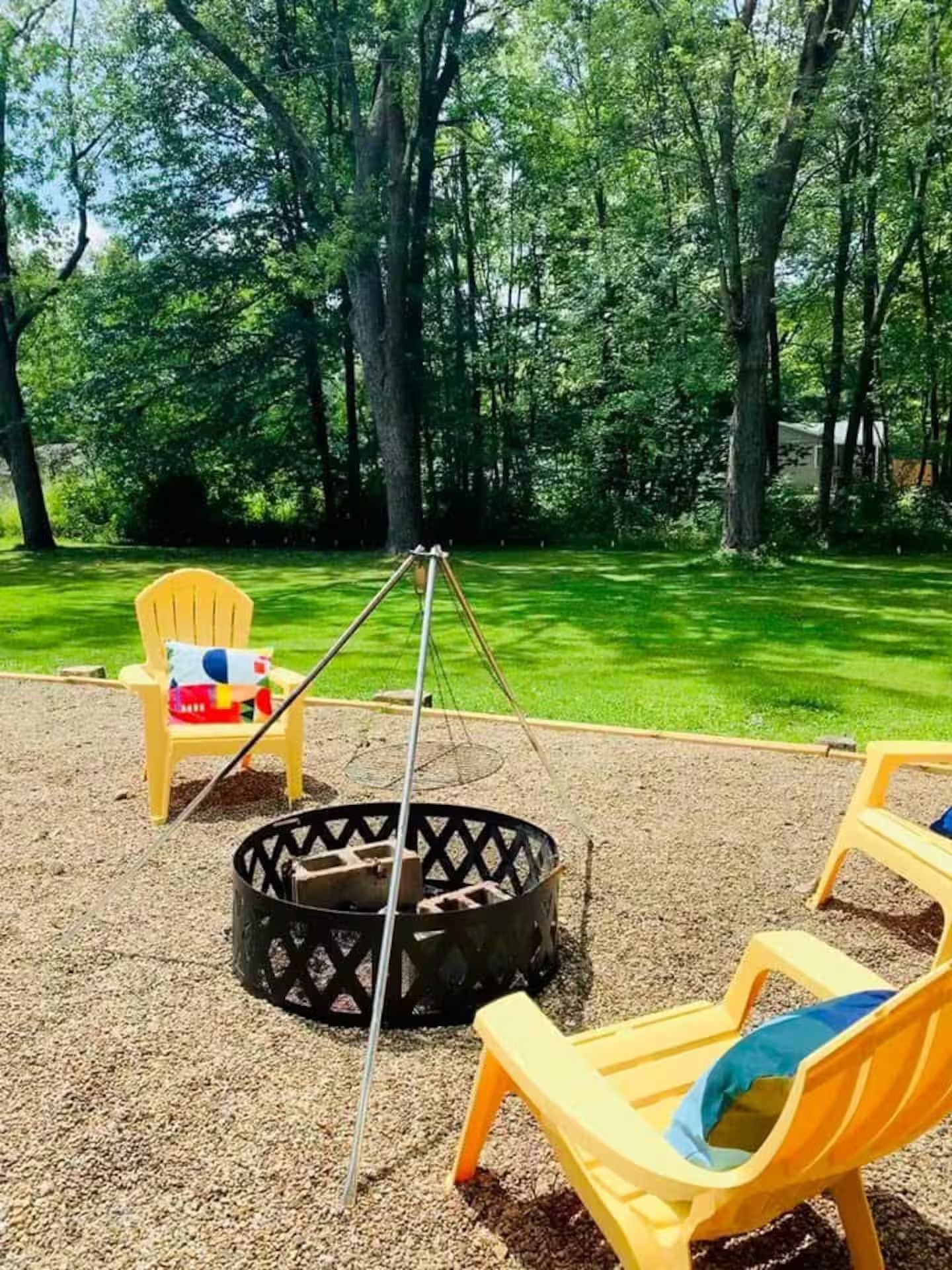 A playground with a swing set, a tire swing, and a fire pit.