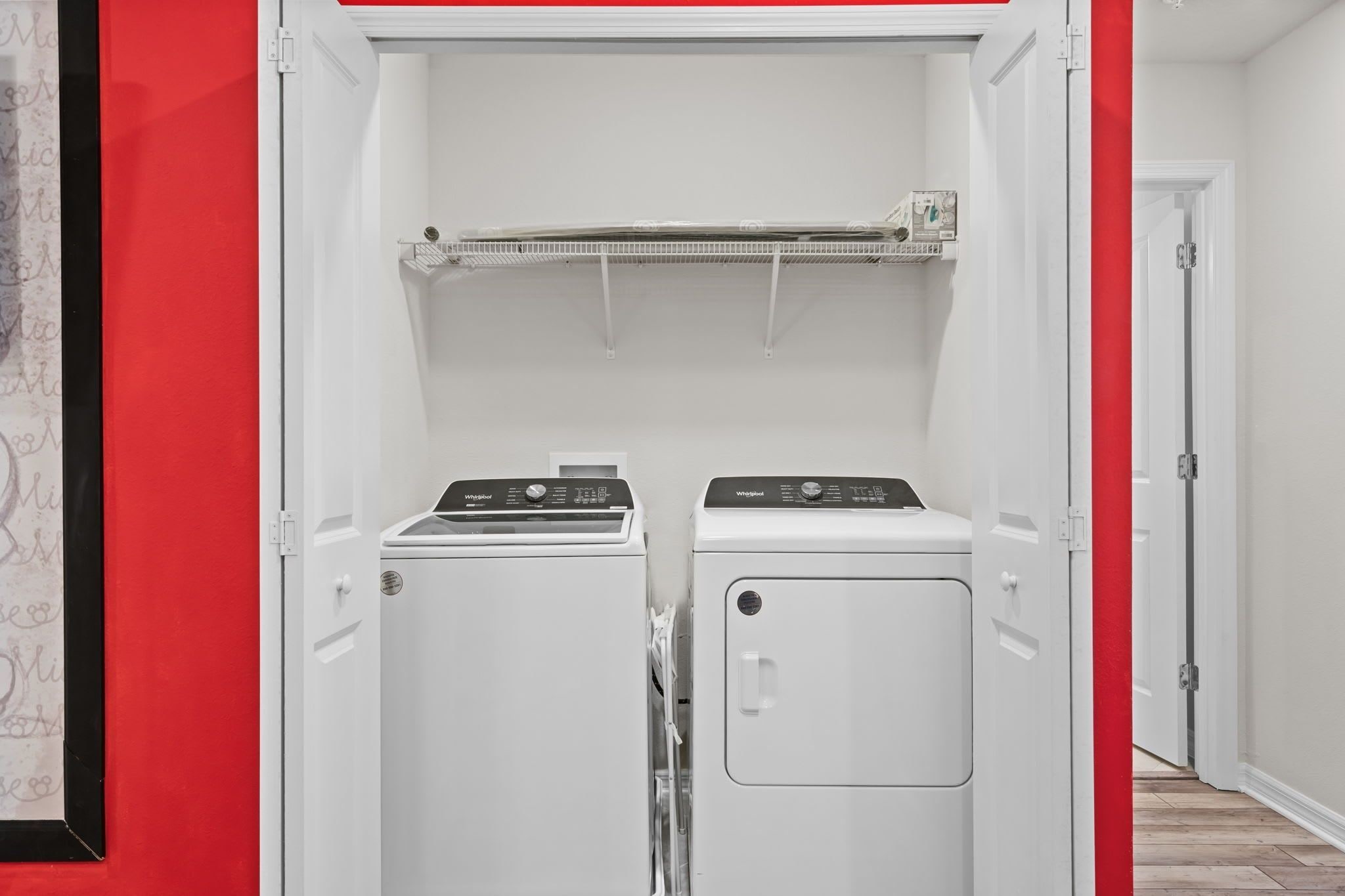 Une buanderie équipée de deux machines à laver blanches et d’un étendoir.