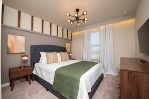 A bedroom with a large bed, a nightstand, a dresser, a ceiling light, and a window with curtains. - 5BR Resort Townhome w/ Pool Near Disney (Davenport)
