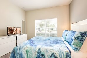 A bedroom with a bed, a TV on a dresser, and a window with blinds. - Family 5BR Retreat w/ Mickey Room Near Disney (Davenport)