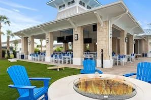 An outdoor patio area with blue chairs and a fire pit. - Luxury 5BR Villa Near Disney w/ Lazy River Access (Davenport)