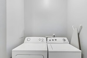 A laundry room with two white front-loading washing machines and a dryer. - Vista Cay 4BR Condo w/ Balcony & Foosball Fun (Orlando)