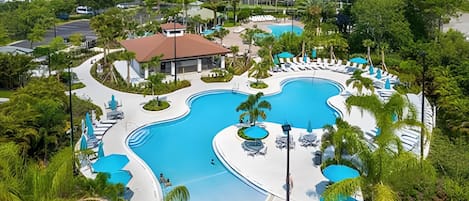 Un resort con varias piscinas, zonas de descanso y abundante vegetación.