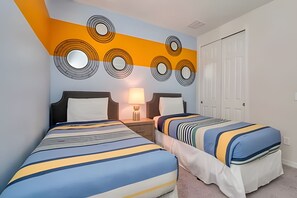 A hotel room with two beds, a nightstand with a lamp, and a wall with circular patterns. - Modern 6BR Villa w/ Pool & Resort Access (Kissimmee)
