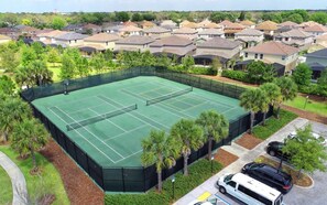 A tennis court surrounded by residential houses, with a parking area and a few vehicles. - 6br/6ba Private Pool Home in Solterra (Davenport)