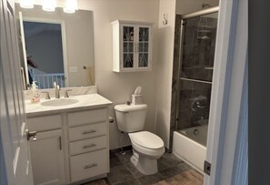 A bathroom with a toilet, sink, and shower. - Cozy 1-bedroom house in peaceful Auburn Hills with AC (Auburn Hills)