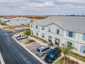 A residential building with multiple units, a parking area, and a road. - 5b/4.5b Pool and Resort (Davenport)