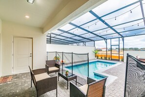 A covered outdoor area with a pool, wicker furniture, and a view of the city. - 5b/4.5b Pool and Resort (Davenport)