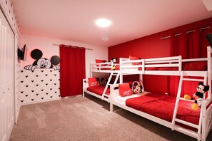 A room with bunk beds, red bedding, Mickey Mouse decorations, and a red wall. - 5b/5b Luxurious Home Storey Lake Resort (Kissimmee)