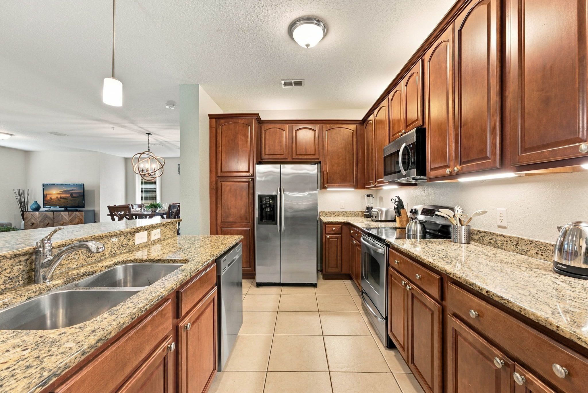 A modern kitchen with granite countertops, stainless steel appliances, and wooden cabinets.