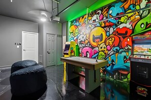 A room with graffiti art on the walls, a pool table, and a gaming machine. - 5BR w/ South Pool, Game Room Storey Lake (Kissimmee)