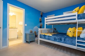 A bunk bed room with a blue wall, a small dresser, and a door leading to another room. - Windsor Island 5BR Villa w/ Pool & Game Room (Davenport)