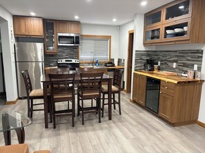 A modern kitchen with wooden cabinets, a stainless steel refrigerator, a built-in microwave, and a dishwasher.