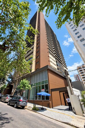 A modern building with a glass facade and a brown exterior. - StayHome Aimberê - Gym & Pool (São Paulo)