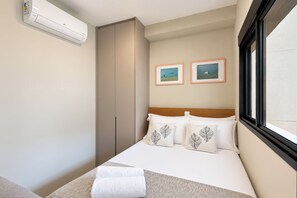 A hotel room with a bed, a wardrobe, a window, and two framed pictures on the wall. - StayHome Aimberê - Gym & Pool (São Paulo)