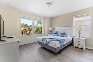 A bedroom with a bed, bedside tables, a desk, and large windows. - Bella Vida 6BR Home Near Disney Parks (Kissimmee)