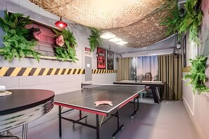 A ping pong table in a room with a striped wall, a hanging plant, and a red light fixture. - Disney 6BR Villa w/ Pool & Themed Rooms (Kissimmee)