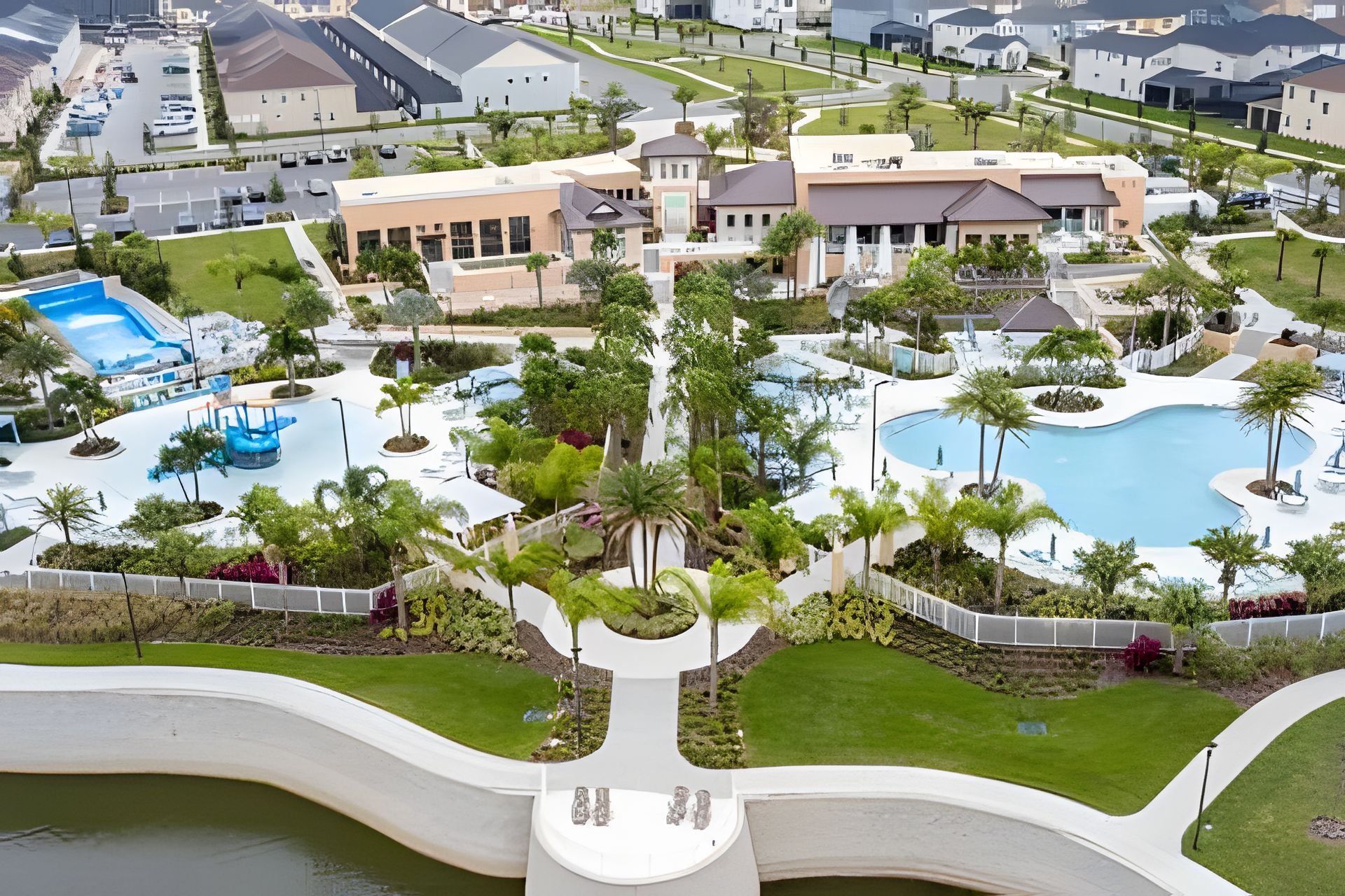 Vue aérienne d’un quartier résidentiel avec une piscine, des jardins aménagés et des maisons modernes.
