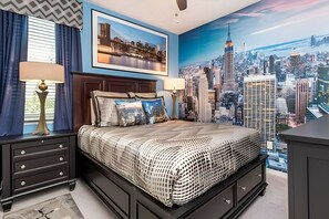 A bedroom with a cityscape mural, a bed with patterned bedding, two bedside tables with lamps, and a dresser. - Disney 6BR Villa w/ Pool & Themed Rooms (Kissimmee)