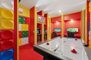 A brightly colored room with a large table for table tennis, a 'LEGO' sign, and arcade games. - 6BR / 5BA Villa w/ Pool & Spa Storey Lake (Kissimmee)