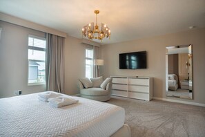 A hotel room with a large bed, a television, a mirror, and a chandelier. - 7bed Villa With Private Pool Solara Resort (Kissimmee)