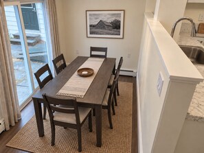 A dining area with a wooden table, chairs, and a rug. - 35 Fairview - Recent reno, 1st floor apt, near ASV (Oneonta)