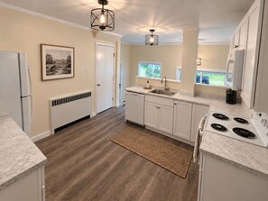 A modern kitchen with white cabinets, a built-in stove, and a window overlooking a backyard. - 35 Fairview - Recent reno, 1st floor apt, near ASV (Oneonta)