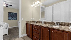A bathroom with a double sink vanity, wooden cabinets, and a ceiling fan. - 7BR Themed Villa w/ Pool 6mi Disney (Kissimmee)