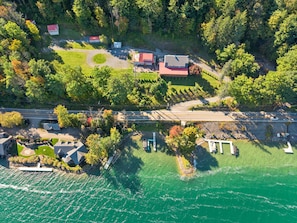An aerial view of a lakeside property with multiple buildings, a dock, and a road. - Hatch's Entire Flock  - 5 unit compound (Cooperstown)