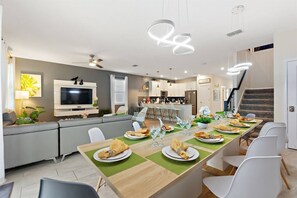 Eine moderne Küche mit Essbereich, integrierten Geräten und einer Treppe zu einer oberen Ebene.