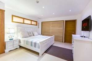 Ein Schlafzimmer mit einem Bett, Nachttischen, einem Fernseher und einem Kleiderschrank.