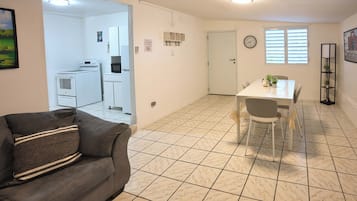 A compact living space with a kitchenette, a dining area, and a seating area with a couch.