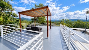 A rooftop terrace with a pergola, seating area, and railing. - Cozy 1-bedroom apartment in serene Aguas Buenas (Aguas Buenas)