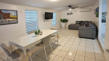 A dining area with a table, chairs, and a ceiling fan.