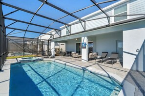 Ein Schwimmbad mit Glasüberdachung, Sitzmöglichkeiten im Freien und einer Terrassenanlage.