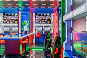 Eine hell erleuchtete Spielhalle mit mehreren Spielstationen, darunter ein Mario Kart Super Circuit Spiel.
