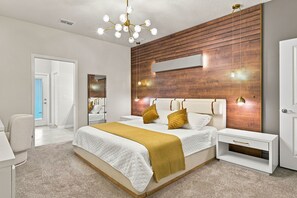Une chambre moderne avec un grand lit, des tables de chevet, une armoire et un mur d’accent en bois.