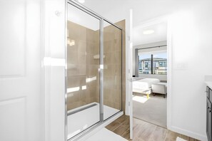 A modern bathroom with a glass shower enclosure, a white sink, and a large mirror. - 12br Home at Paradiso Grande, Near Disney (Orlando)