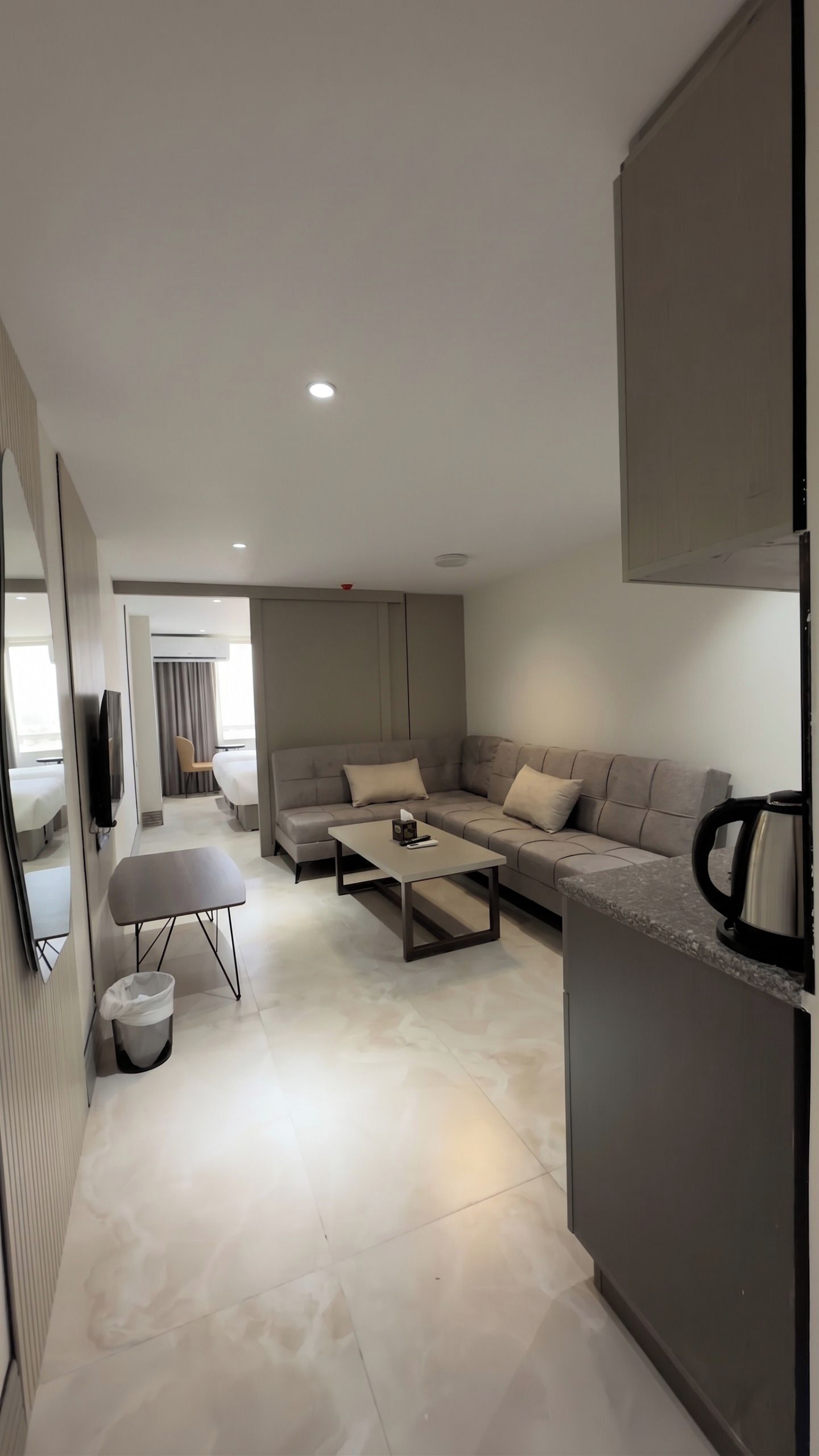 A modern living room with a sofa, a coffee table, and a TV.