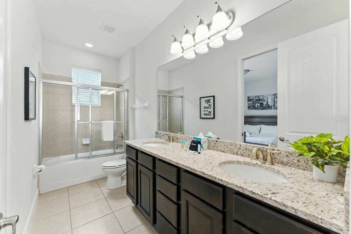 A modern bathroom with a walk-in shower, a large mirror, and a double sink vanity.