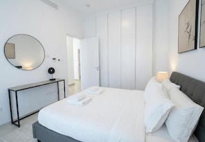 Ein modernes Schlafzimmer mit einem Bett, einem Nachttisch und einem großen Kleiderschrank.