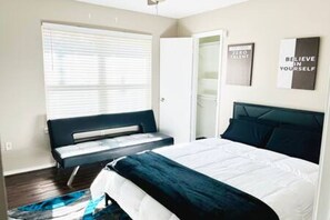 Un dormitorio con una cama, un banco y una ventana.