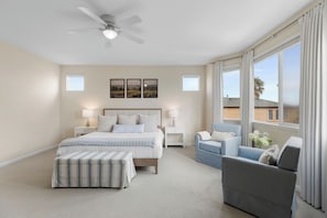 A bedroom with a bed, a chair, a nightstand, a floor lamp, a ceiling fan, and a window with curtains. - Wine Country Retreat 5BR w/ Hot Tub (American Canyon)