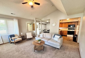 A living room with a sofa, chairs, a coffee table, and a ceiling fan. - 511 Serenity on Shugart (Beatrice)