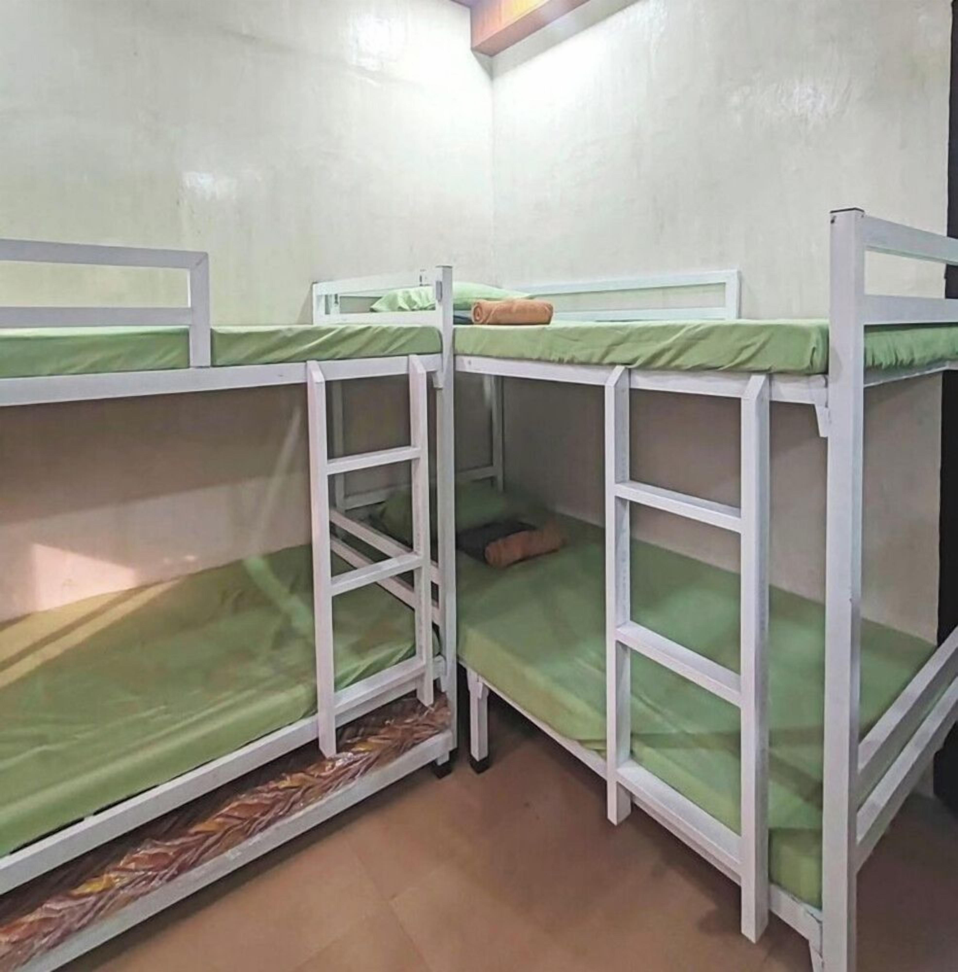 Una habitación con literas, una escalera y una pequeña mesa.