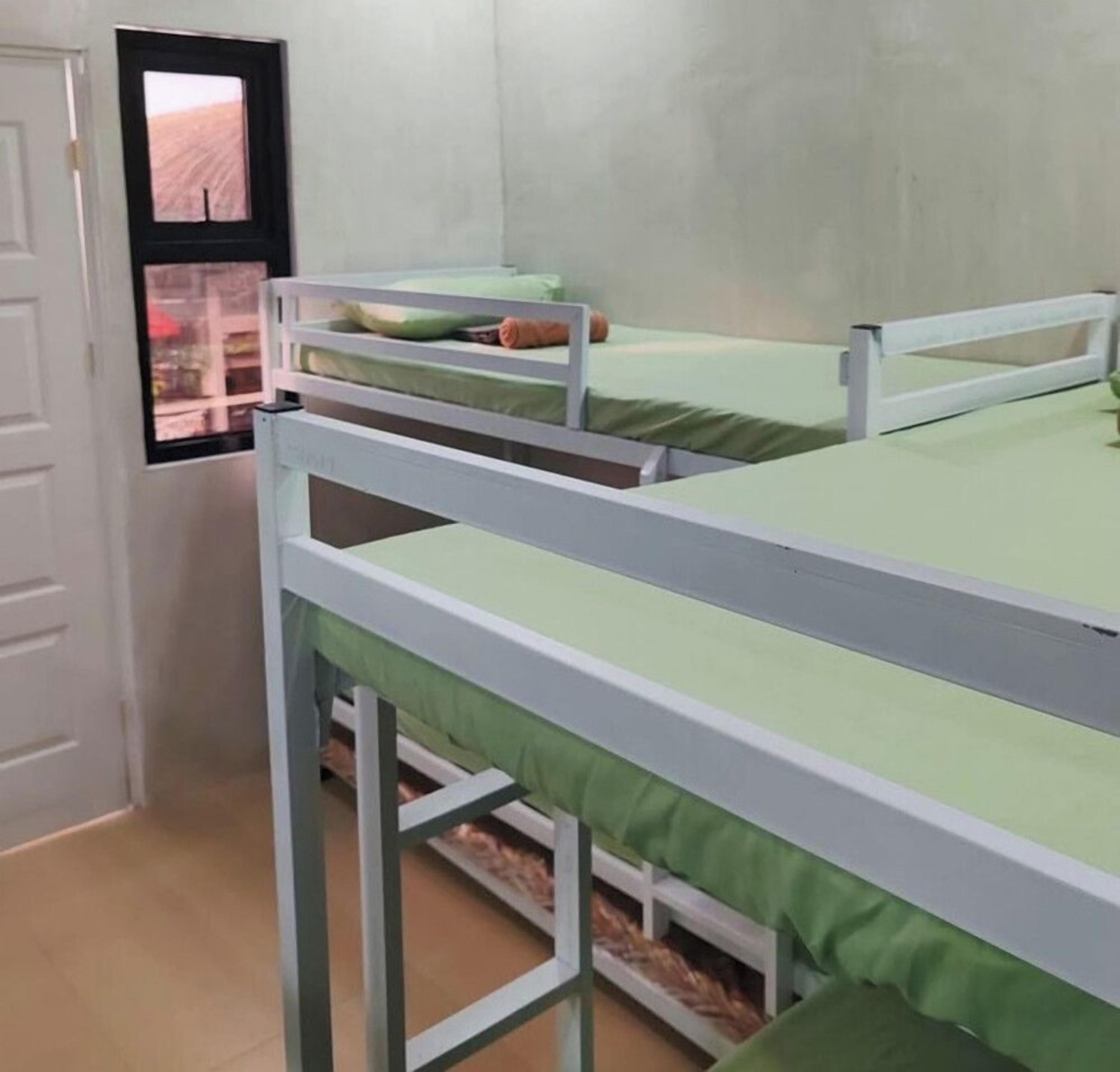 Een kamer met stapelbedden, een deur en een raam met uitzicht.