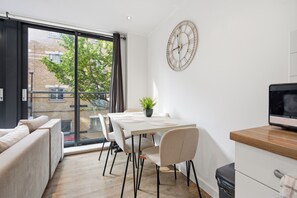 Eine moderne Küche mit Essbereich, großen Fenstern und Blick ins Freie.