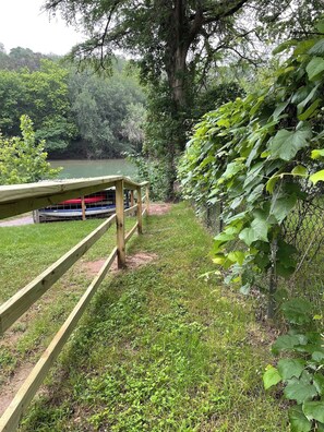 A wooden bridge over a body of water with boats docked on the opposite side. - Pets Welcome! Tiny House + Guadalupe River Access (New Braunfels)