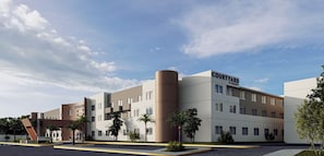 Hotel Courtyard by Marriott amb disseny modern, que destaca per un pati central, diverses plantes i un teulat pla.