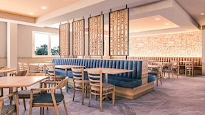 Interior de restaurant amb seients, taules i cadires.